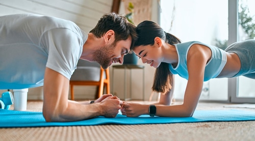 Couple doing plank exercises at Sculpted by Stacey RN.